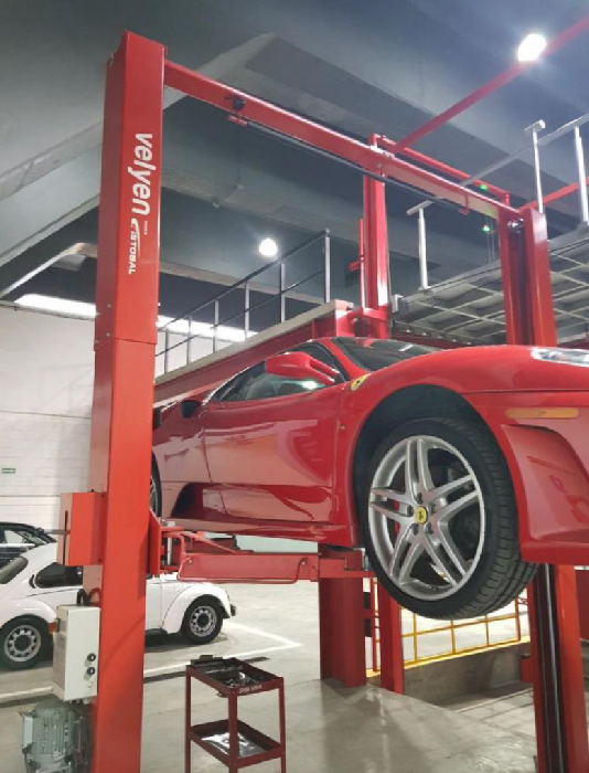 Elevador Velyen en uso en taller con vehículo elevado